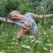 Bloemenweide met spelende kinderen