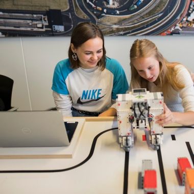 2 jongeren programmeren de straddle carrier uit LEGO