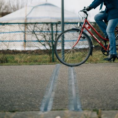 Een fietser rijdt over de telslang bij een vast telapparaat.