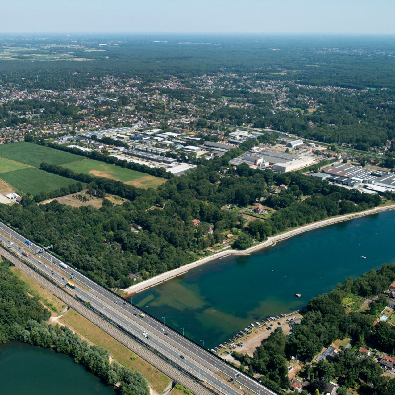 Luchtfoto bedrijventerreinen Kloosterveld en De Zwaan, woonkern, landbouwgebied, snelweg E19 en E10-plas