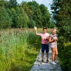 jongen en meisje lachend en wuivend