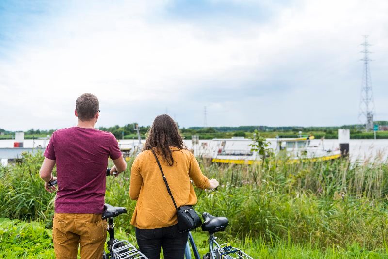 fietsers kijken uit over water